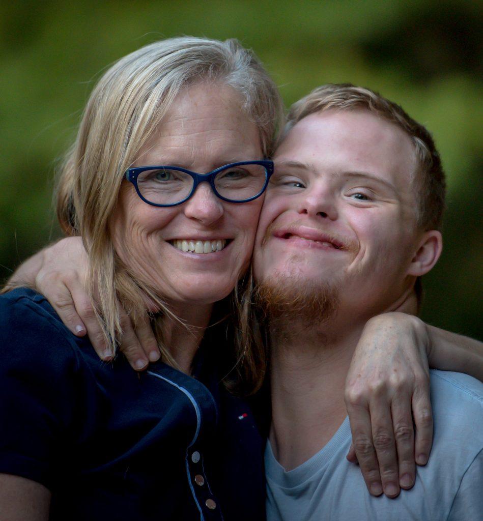 A mother embraces her disabled son