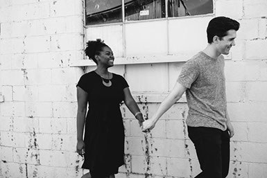 A young man and woman hold hands