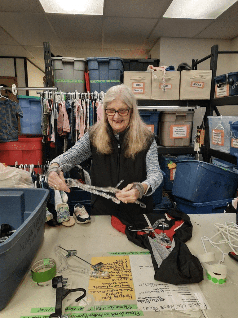 An older woman working at the desk of the Sooke Family Resource Society Thrift Shop.